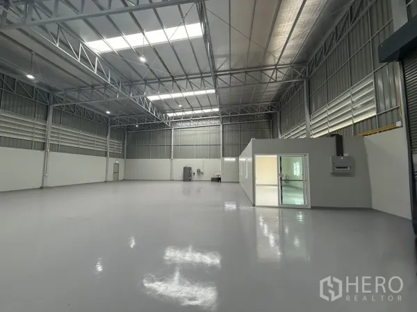 货栈 出租在Bang Khen, Bangkok - 宽敞作业区，连通卷闸门入口与通风百叶，旁设独立办公室模块。