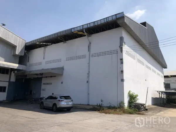 工厂 出租在Mueang Samut Prakan, Samut Prakan - 高挑屋脊的工厂外立面，设装卸平台与卷帘门。