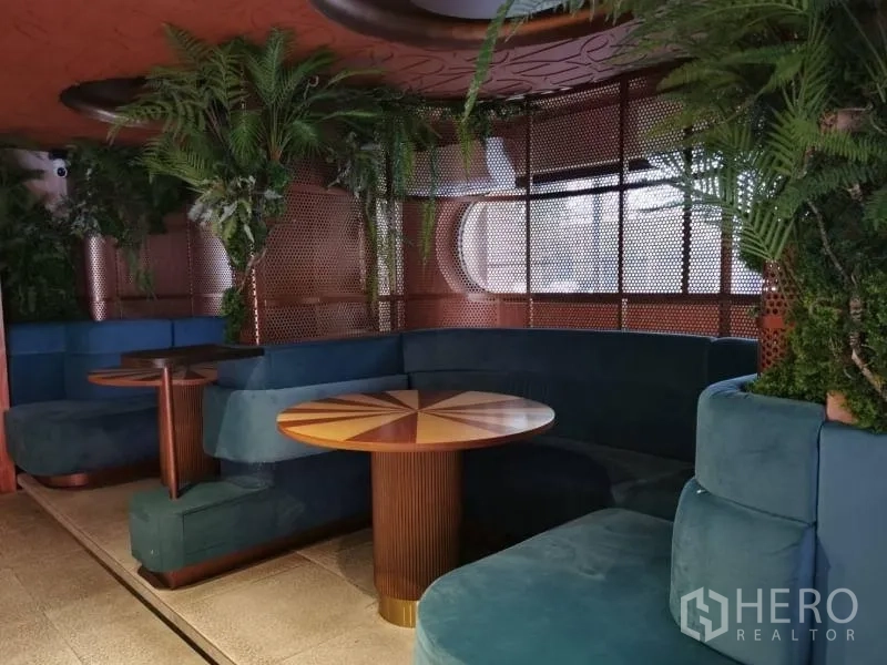 พื้นที่ขายปลีก ให้เช่า - โซนบูธส่วนตัว โซฟาสีเขียว โต๊ะกลมลายไม้ และต้นไม้ตกแต่ง