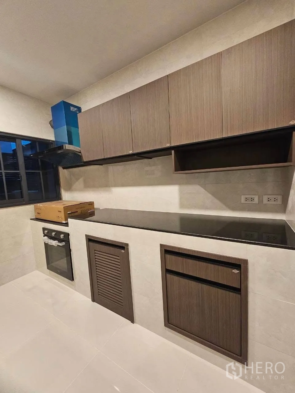 独栋房屋 for rent or sale in Bang Phli, Samut Prakan - 厨房长操作台与成排橱柜，旁有窗户。
