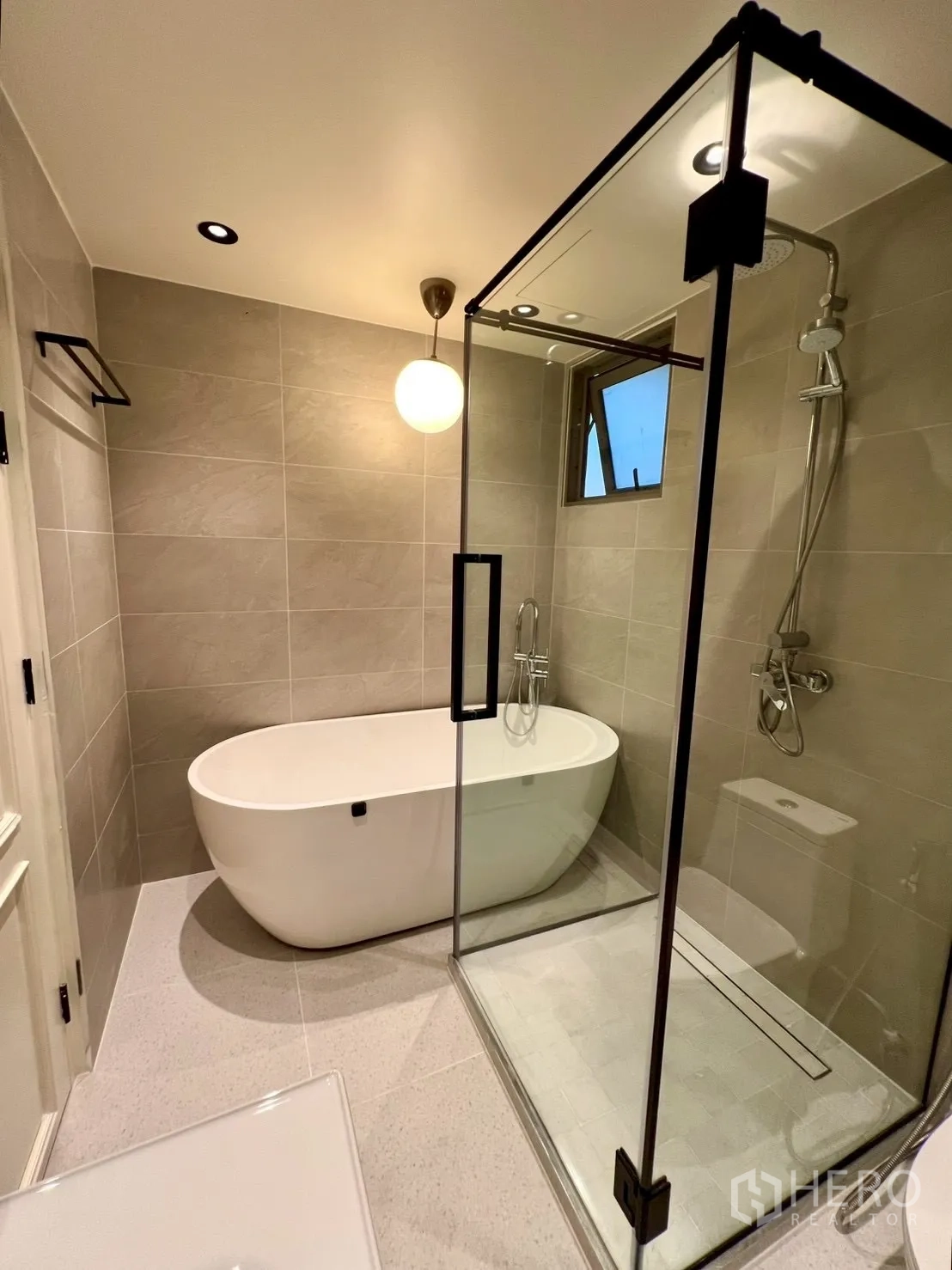 Condominium for sale in Watthana, Bangkok - Bathroom with freestanding soaking tub and separate glass shower.