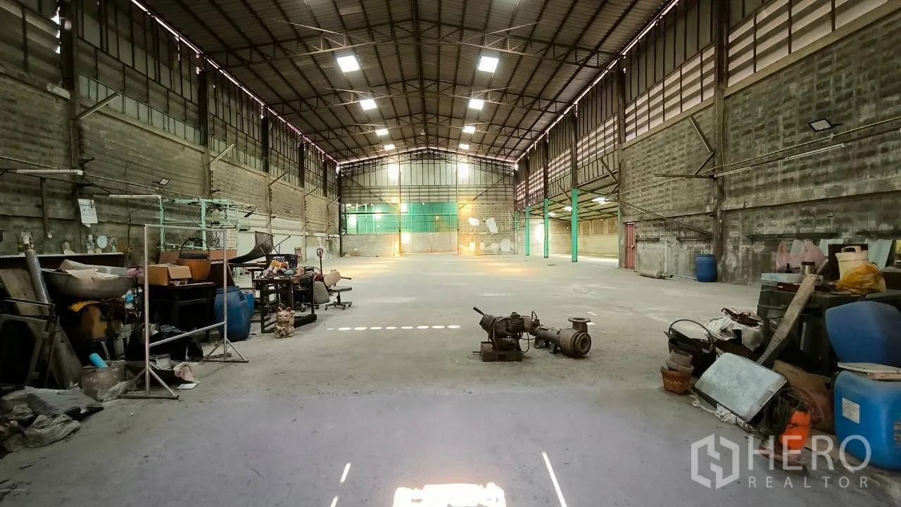 Factory for rent in Mueang Samut Prakan, Samut Prakan - Wide manufacturing floor with roof windows and storage along the sides.