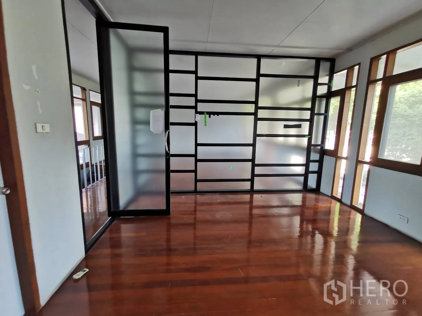 Home Office for rent in Watthana, Bangkok - Private office with frosted glass grid partition and glossy hardwood flooring.