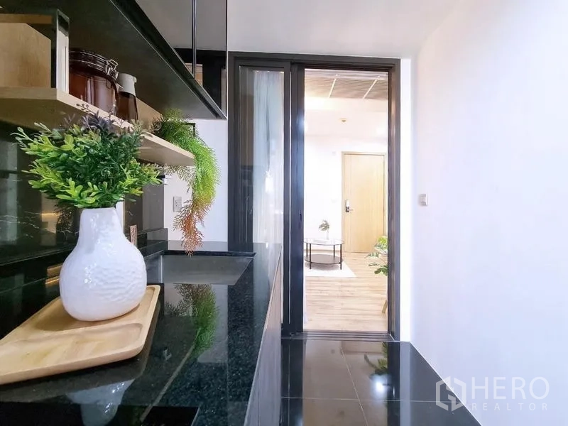 公寓 出售 - 从厨房望向客厅的视角，玻璃门与亮面黑色地面。