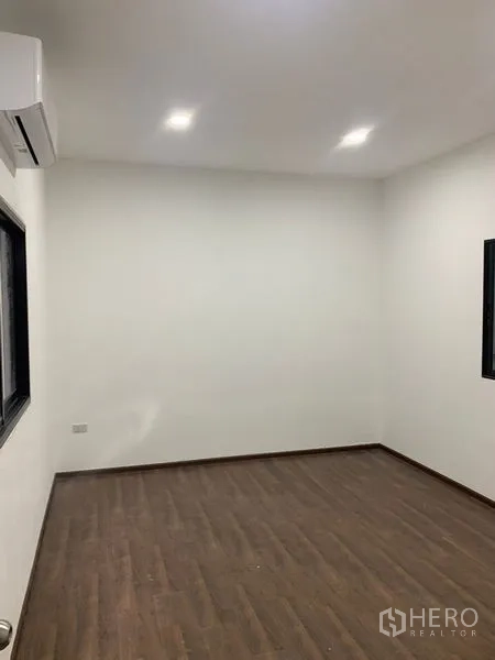 Warehouse for rent in Bangkok - Air-conditioned office room with wood flooring, recessed lights, and black-framed windows.