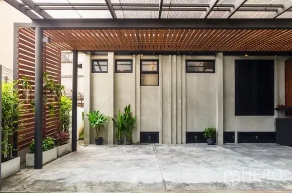 ทาวน์เฮาส์ ให้เช่าในKhlong Toei, Bangkok - ที่จอดรถมีหลังคาระแนงไม้ ผนังคอนกรีต และต้นไม้กระถาง