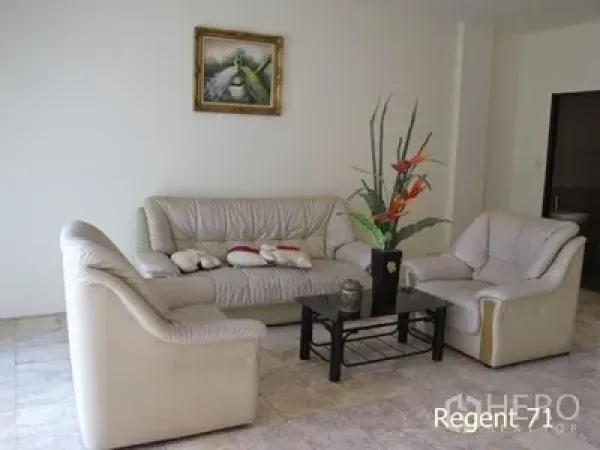 ทาวน์เฮาส์ ให้เช่าในKhlong Toei, Bangkok - ห้องนั่งเล่นสว่างด้วยโซฟาหนังสีครีม โต๊ะกลางกระจก และพื้นกระเบื้อง