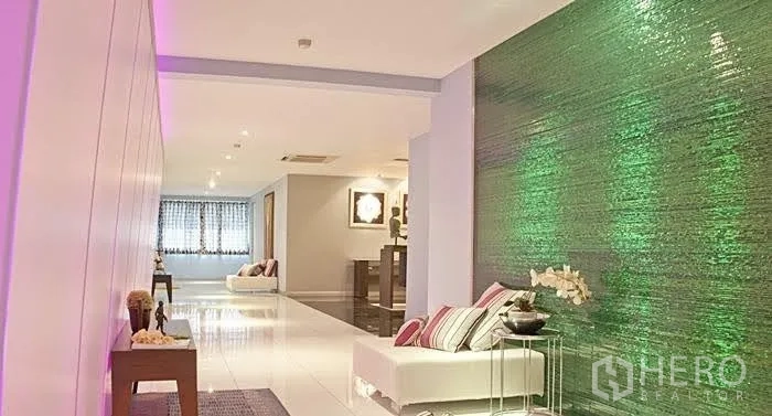 Condominium for rent in Yan Nawa, Bangkok - Hallway with an illuminated green feature wall, accent lighting and lounge seating.