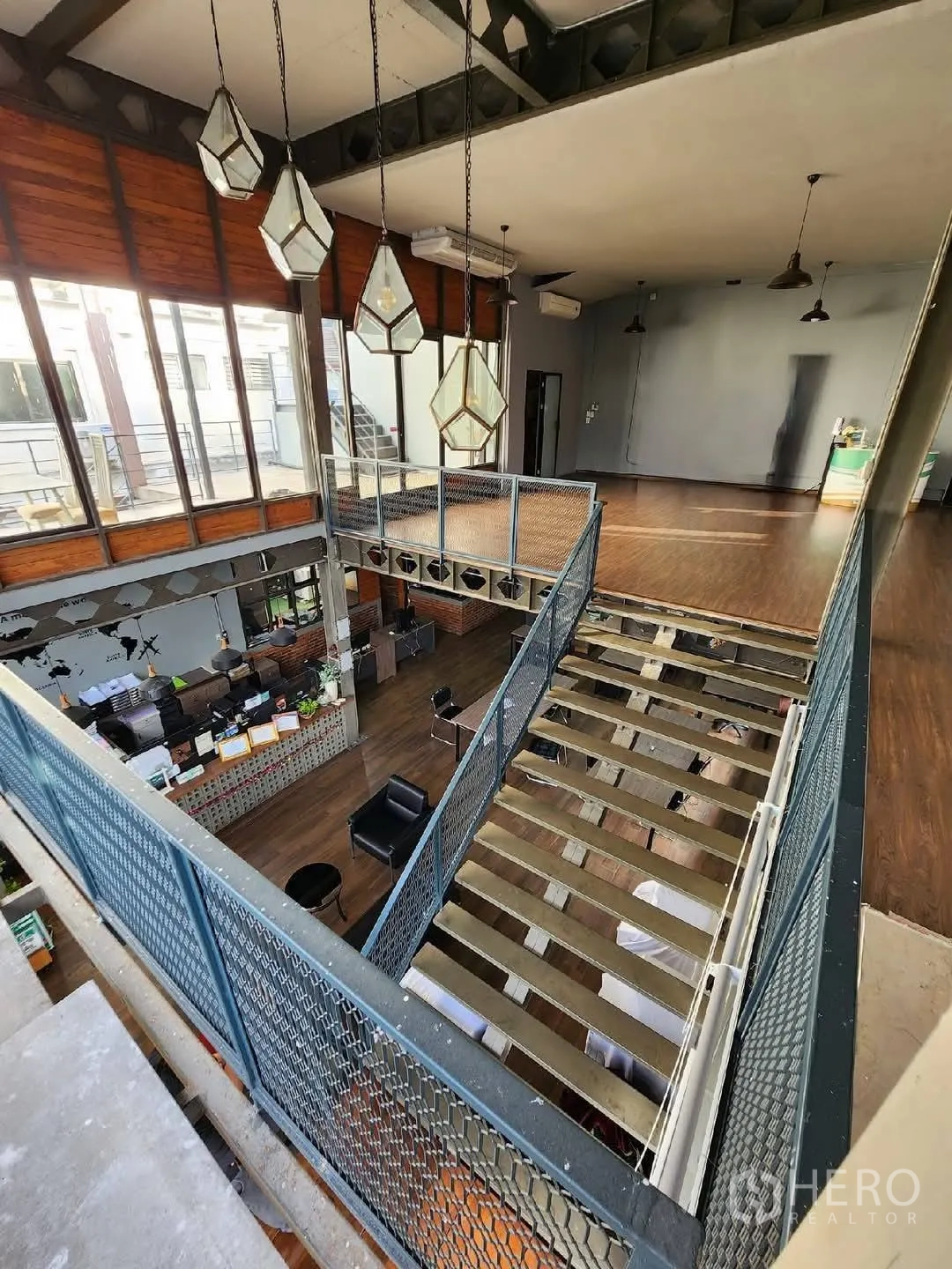 Home Office for rent in Mueang Nonthaburi, Nonthaburi - Open atrium with pendant lights, mezzanine walkway and warm wood floors.