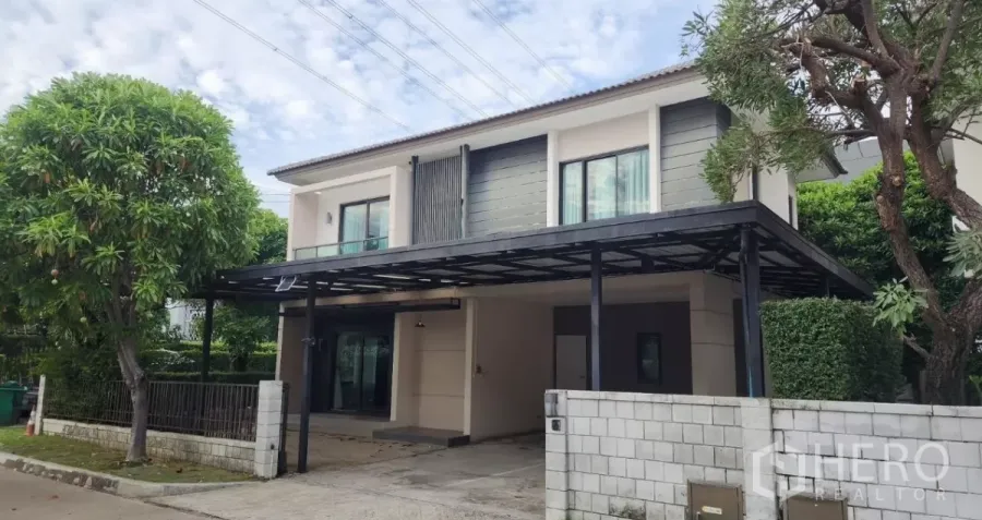 Detached House for rent in Samut Prakan - Modern two-storey detached house on a corner plot with covered carport and mature trees.