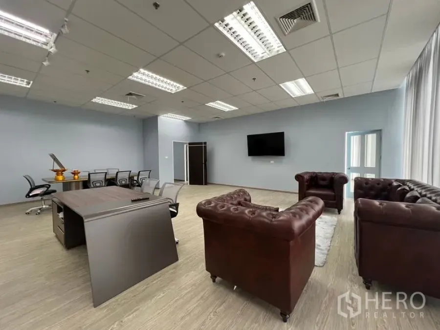 办公空间 出租 - 行政办公区，棕色皮沙发、会议桌和墙挂电视。
