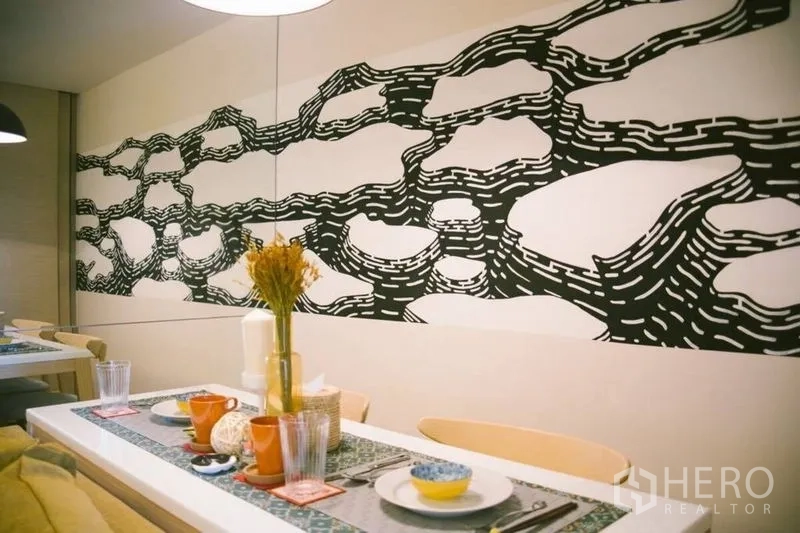 คอนโด ขายในWatthana, Bangkok - พื้นที่รับประทานอาหารจัดโต๊ะเรียบร้อย ใต้ผนังลวดลายกราฟิกขาวดำโดดเด่น.