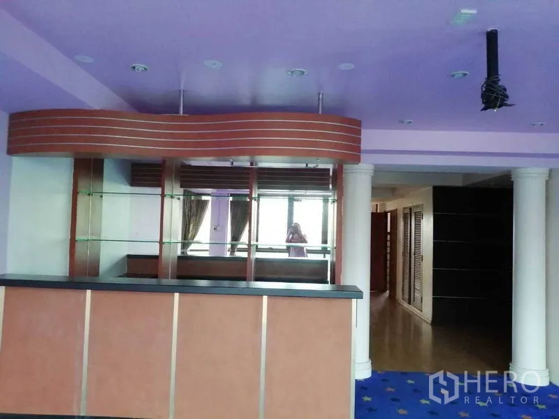 办公空间 出租在Khlong Toei, Bangkok - 吧台/茶水间，带镜面置物架、紫色天花与装饰柱。