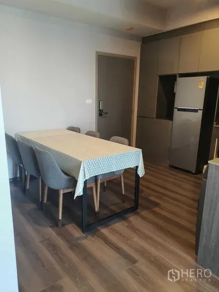 Condominium for rent - Dining area with rectangular table and four upholstered chairs beside built-in kitchen cabinetry.