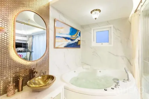 联排别墅 出租在Lat Phrao, Bangkok - 奢华浴室，圆形按摩浴缸，大理石墙面与金色台盆及六角砖背景。