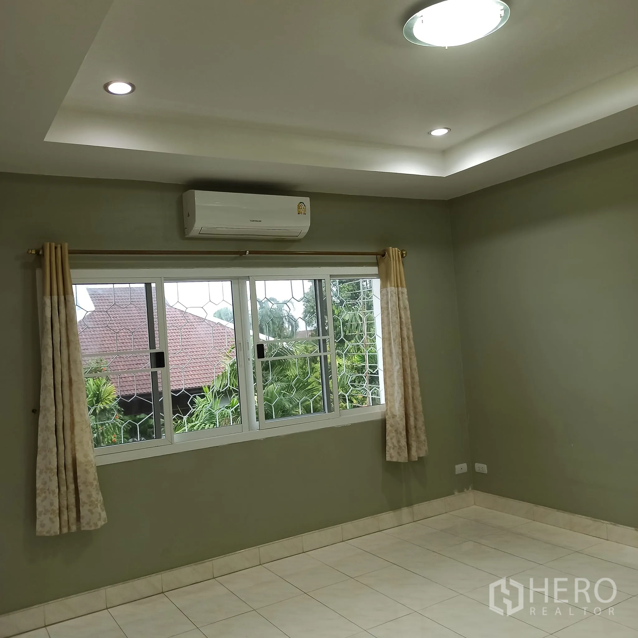 Townhouse for rent in Wang Thonglang, Bangkok - Room with air conditioner and window overlooking greenery.