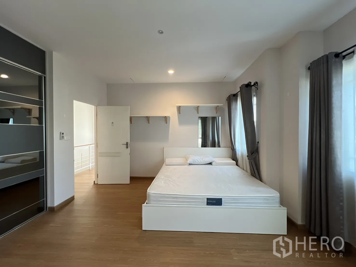 บ้านเดี่ยว for rent in Bang Kapi, Bangkok - ห้องนอนพร้อมเตียง ชั้นวาง และหน้าต่างหลายบานพร้อมผ้าม่าน.