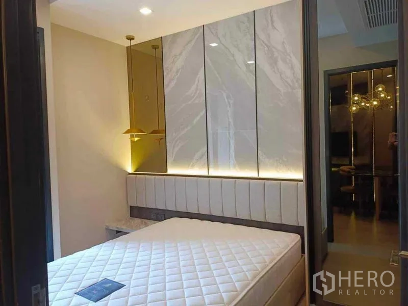 公寓 出租在Watthana, Bangkok - 卧室软包床头与大理石装饰墙，床侧吊灯