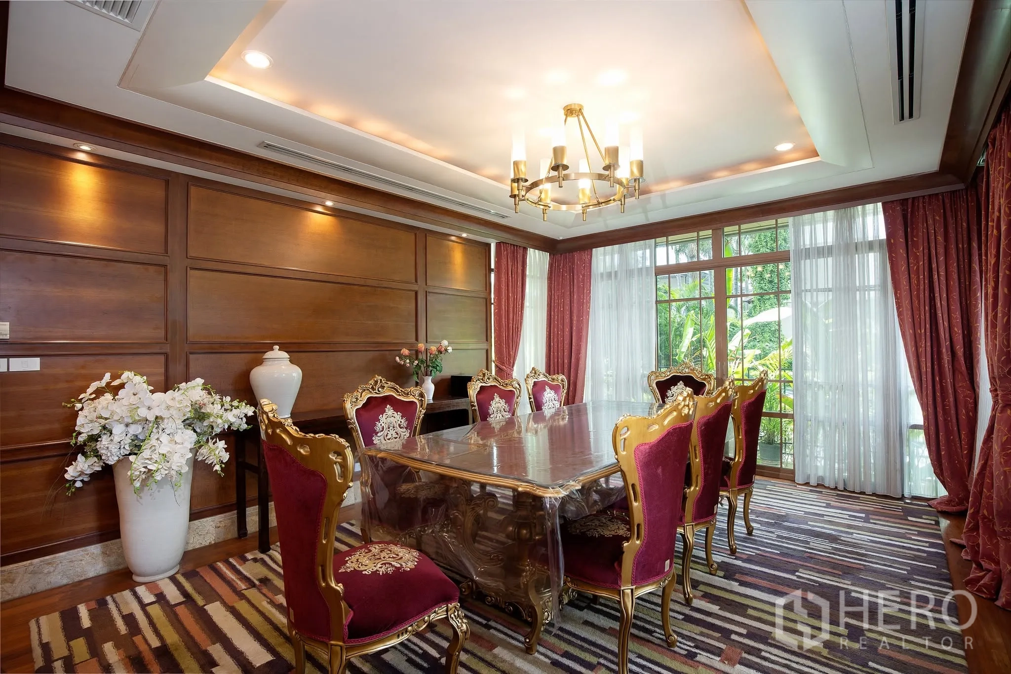 独栋房屋 for rent or sale in Watthana, Bangkok - 餐厅面向花园，落地玻璃门引入景观。