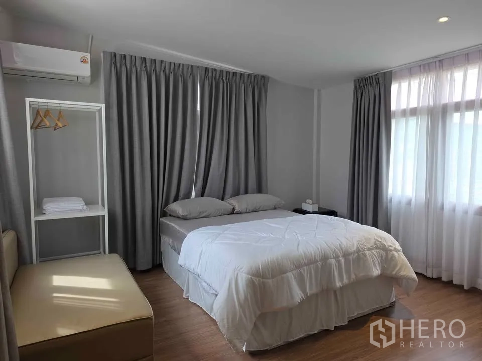 บ้าน ให้เช่าในKhlong Toei, Bangkok - ห้องนอนเตียงคู่ ผ้าม่านสีเทา แอร์ และราวแขวนเสื้อแบบเปิด