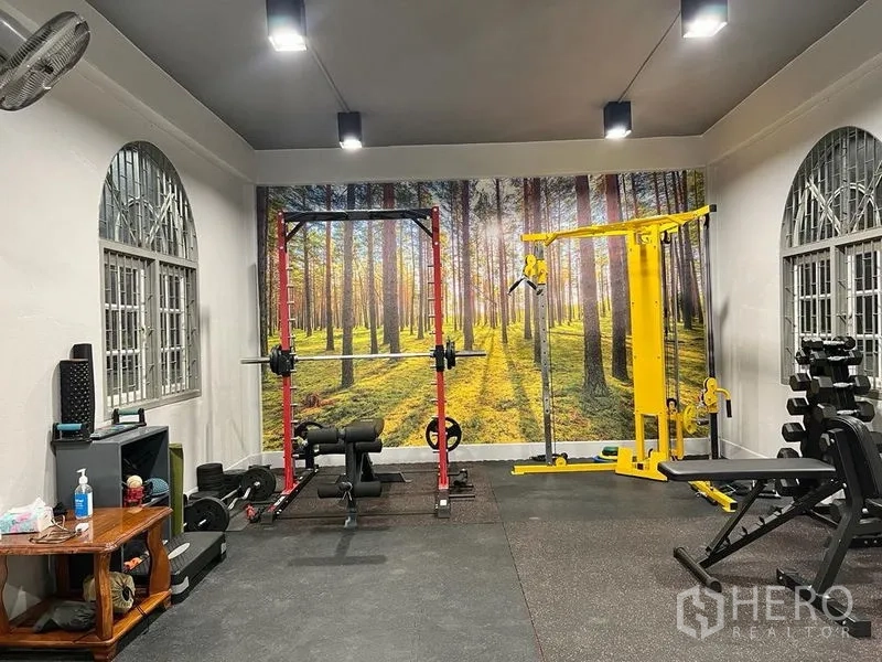 Shophouse for sale in Bang Kho Laem, Bangkok - Home fitness room with strength equipment and a forest mural.