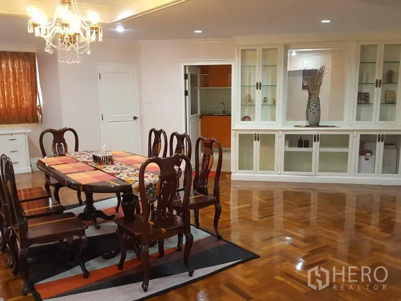 คอนโด ให้เช่าในWatthana, Bangkok - ห้องทานข้าวแบบเป็นทางการ โต๊ะไม้ 8 ที่นั่ง โคมชานเดอเลียร์ และตู้โชว์กระจก