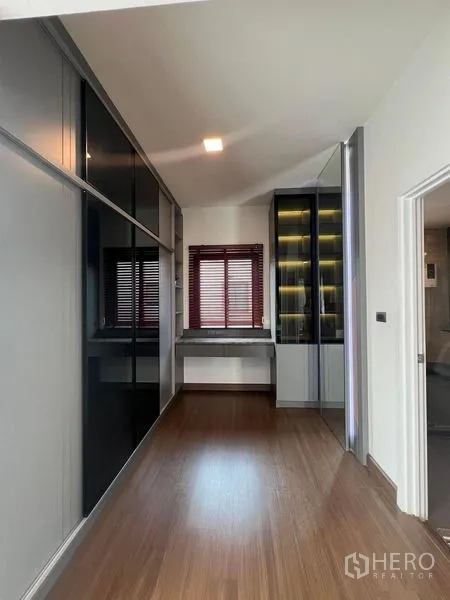Detached House for rent or sale - Walk-in closet corridor with glass display cabinet and work desk.