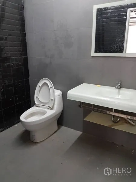 Home Office for rent or sale in Khlong Toei, Bangkok - Second bathroom with gray wall tiles and a floating sink counter.