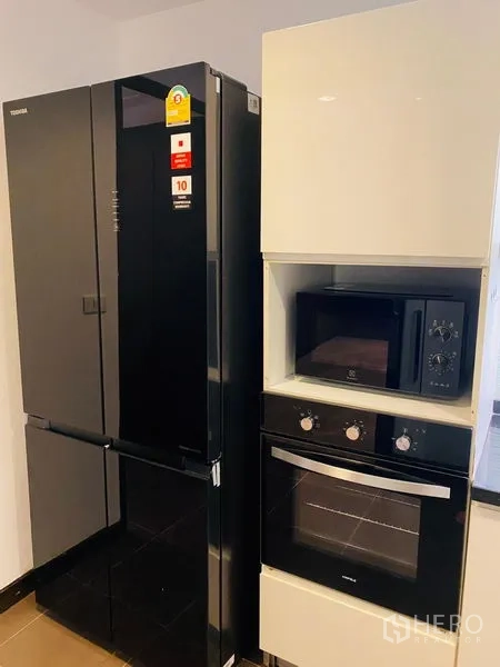 Condominium for rent in Watthana, Bangkok - Appliance wall showcasing a double-door refrigerator with built-in oven and microwave.