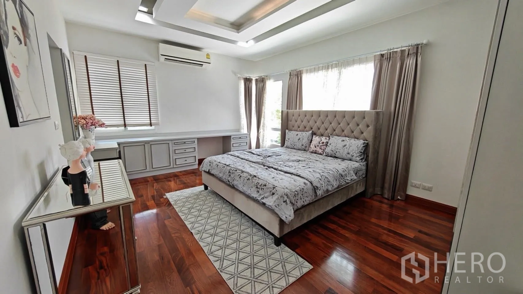 Detached House for rent or sale in Bang Phli, Samut Prakan - Wide view of a bedroom featuring a tufted headboard, coffered ceiling, and corner windows with drapes.