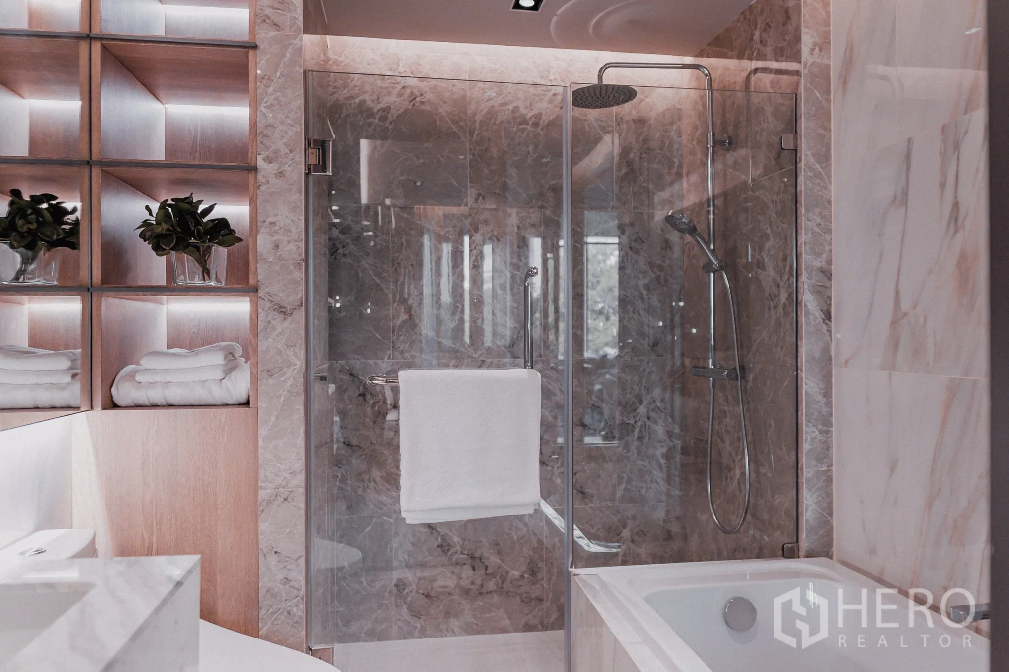 公寓 出售 - 大理石卫浴，玻璃淋浴间配顶喷花洒与浴缸，置物格带背光。