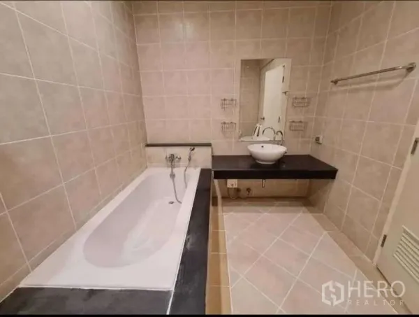 ทาวน์เฮาส์ ให้เช่าในPhra Khanong, Bangkok - ห้องน้ำพร้อมอ่างอาบน้ำ เคาน์เตอร์อ่างล้างหน้า และผนังกระเบื้องโทนอบอุ่น