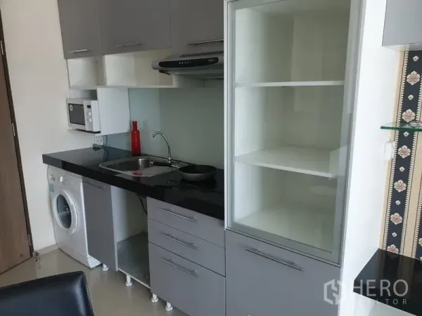 คอนโด ให้เช่าในKhlong Toei, Bangkok - ครัวขนาดกะทัดรัด ท็อปสีดำ ซิงก์ เครื่องดูดควัน ไมโครเวฟ ตู้เก็บของ และเครื่องซักผ้าในห้อง