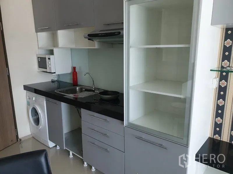 คอนโด ให้เช่าในKhlong Toei, Bangkok - ครัวขนาดกะทัดรัด ท็อปสีดำ ซิงก์ เครื่องดูดควัน ไมโครเวฟ ตู้เก็บของ และเครื่องซักผ้าในห้อง