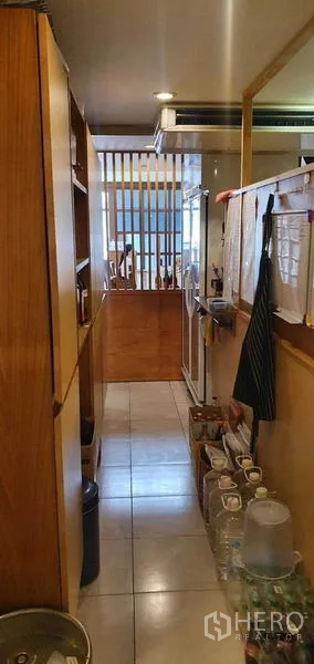 店屋 出租在Khlong Toei, Bangkok - 走廊一侧为储物架，通向木质元素的就餐区