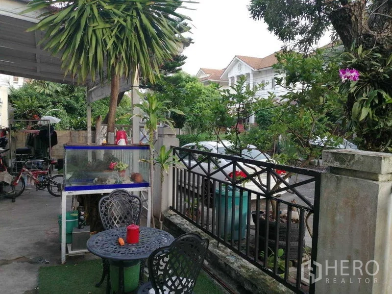 บ้าน ขายในPrawet, Bangkok - เฉลียงหน้าบ้านมีชุดโต๊ะสนาม ต้นไม้ และรั้วโลหะ