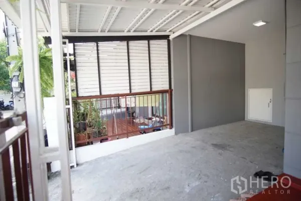 Townhouse for rent in Suan Luang, Bangkok - Covered carport and front terrace with privacy screen and potted plants.