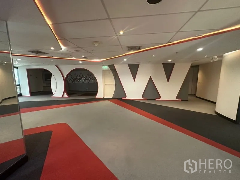 Office Space for rent in Khlong Toei, Bangkok - Lobby area featuring oversized letter wall decor, curved openings, and warm accent lighting.