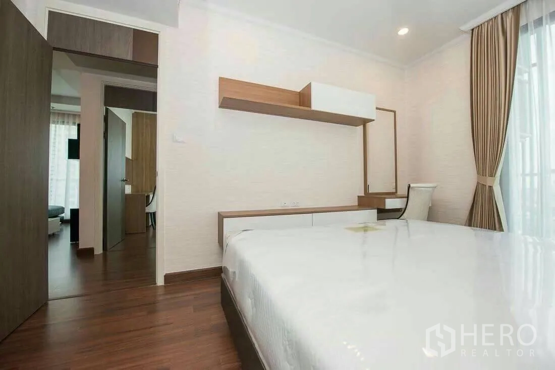 Condominium for rent in Sathon, Bangkok - Second bedroom with built‑in shelves, vanity and full‑height curtains.