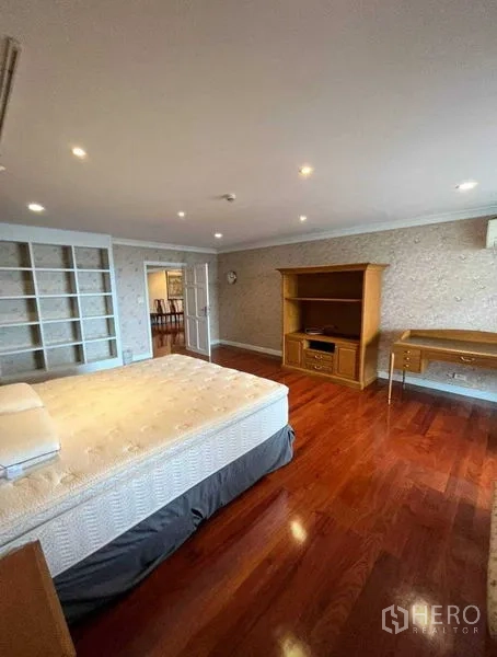 คอนโด ให้เช่าในWatthana, Bangkok - ห้องนอนขนาดใหญ่ เตียงคิงไซซ์ ชั้นวางและโต๊ะทำงานบิลท์อิน พร้อมพื้นไม้โทนอุ่น