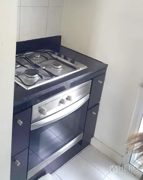 Detached House for rent in Wang Thonglang, Bangkok - Built-in gas hob and electric oven set in a black countertop alcove.