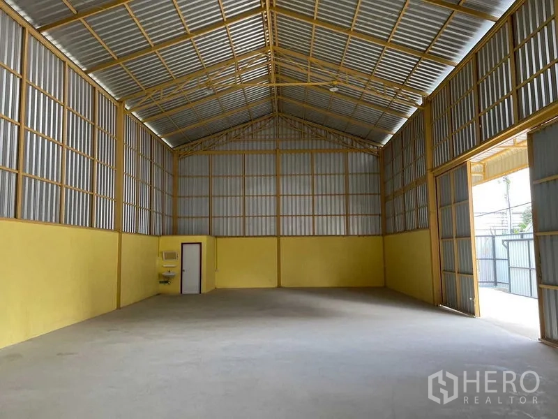 คลังสินค้า ให้เช่าในLat Krabang, Bangkok - ฮอลล์โกดังมองไปยังประตูโหลดสูง พร้อมอ่างล้างมือและประตูทางออกด้านข้าง