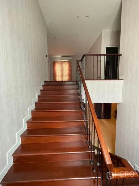 Detached House for sale in Mueang Samut Prakan, Samut Prakan - Timber staircase with iron balusters leading to the upper floor landing.