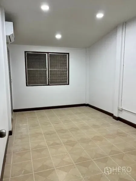 ทาวน์เฮาส์ ให้เช่าในDin Daeng, Bangkok - ห้องนอนรอง พื้นกระเบื้องโทนอบอุ่น มีหน้าต่างคู่และไฟสปอตไลท์.