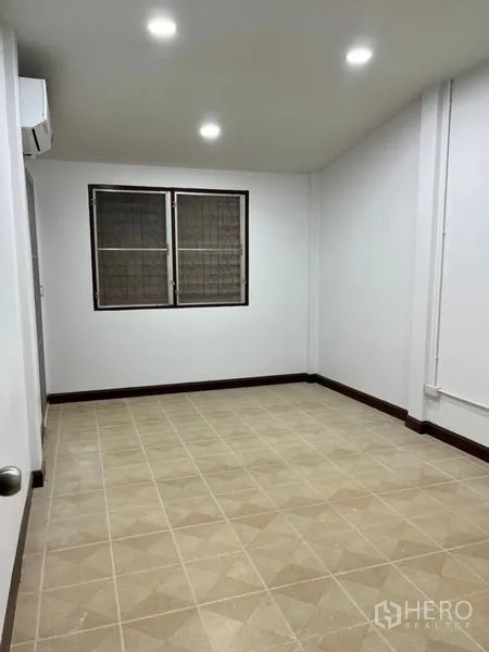 ทาวน์เฮาส์ ให้เช่าในDin Daeng, Bangkok - ห้องนอนรอง พื้นกระเบื้องโทนอบอุ่น มีหน้าต่างคู่และไฟสปอตไลท์.