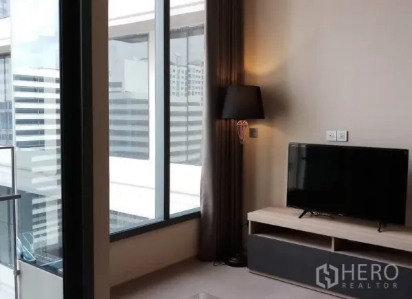 公寓 出租在Khlong Toei, Bangkok - 落地窗转角空间，电视柜与落地灯，可眺望曼谷楼群