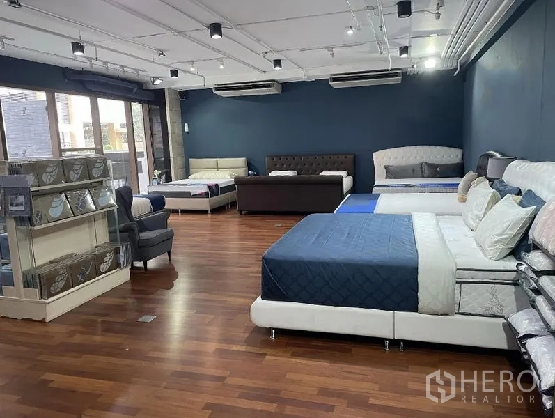 พื้นที่ขายปลีก ให้เช่า - โชว์รูมค้าปลีกกว้าง พื้นไม้ ผนังสีน้ำเงิน ไฟราง และกระจกบานใหญ่พร้อมแอร์