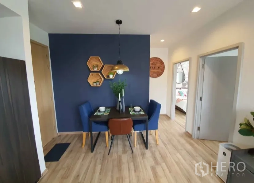 Condominium for rent in Chatuchak, Bangkok - Dining nook with a navy accent wall, pendant light and a four-seat table.