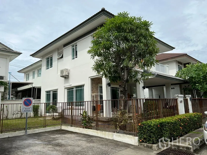 Detached House for rent in Bang Kapi, Bangkok - Two-storey white detached house with fenced garden and driveway in a gated community.