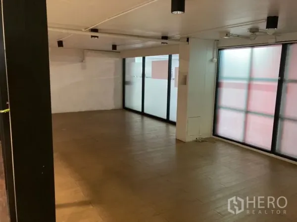 零售空间 出租在Khlong Toei, Bangkok - 开放式店内空间，木纹地砖、磨砂玻璃与吸顶射灯。